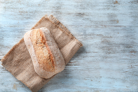 Fresh tasty bread on wooden background