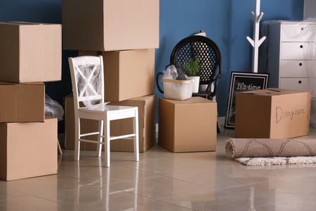 Carton boxes and interior items on floor in room. Moving house concept