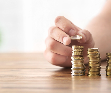 Man stacking coins on table. Savings conceptの写真素材