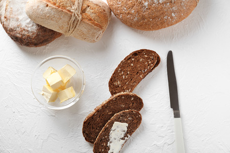 Composition with sliced tasty bread and butter on light background