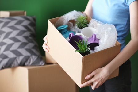 Woman with packed carton box indoors. Moving house conceptの写真素材