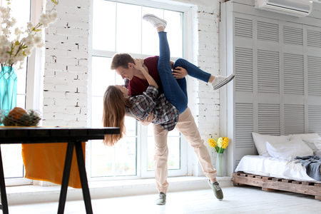 Happy young couple dancing at homeの写真素材