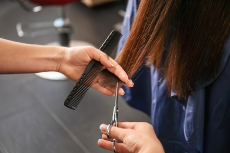 Professional hairdresser working with client in beauty salonの写真素材