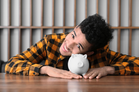 African-American man with piggy bank at table. Savings conceptの写真素材