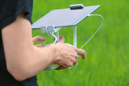 Man operating modern drone outdoors