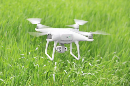 Modern quadcopter flying over fieldの写真素材