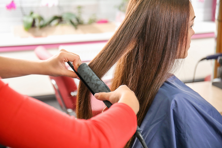 Professional hairdresser working with client in beauty salonの写真素材