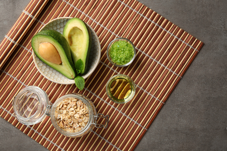 Avocado with ingredients for natural homemade cosmetics on bamboo matの写真素材