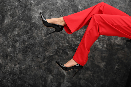 Legs of beautiful young woman on dark grey backgroundの写真素材