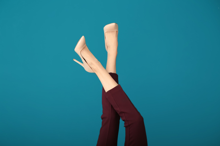 Legs of beautiful young woman on color backgroundの写真素材