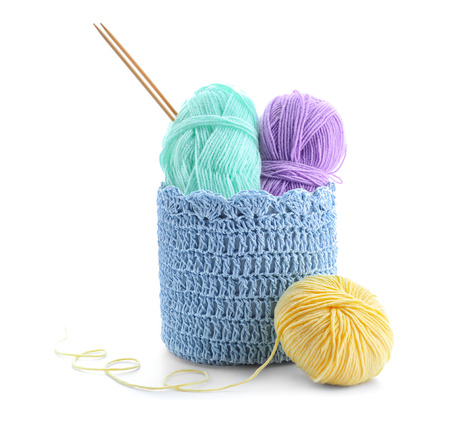 Basket with knitting yarn and needles on white backgroundの写真素材