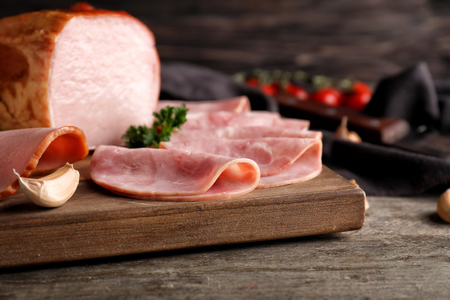 Board with delicious sliced ham on wooden table, closeupの写真素材