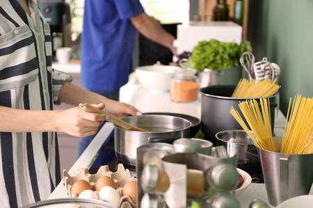 Young woman cooking in kitchenの写真素材