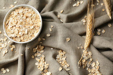 Bowl with oatmeal flakes on tableの写真素材