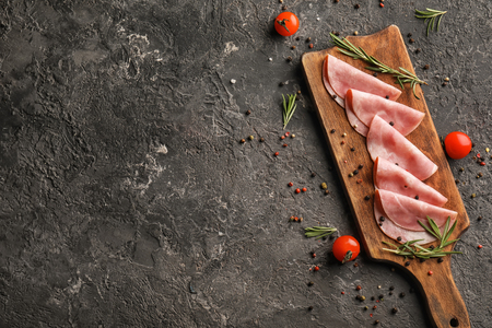 Board with delicious sliced ham on textured tableの写真素材