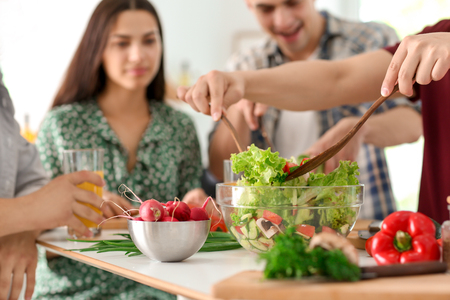 Friends cooking together in kitchenの写真素材