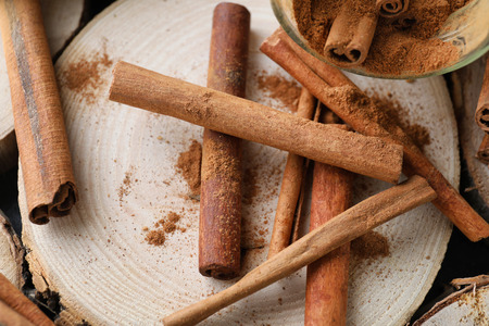 Aromatic cinnamon sticks on wooden background, closeup
