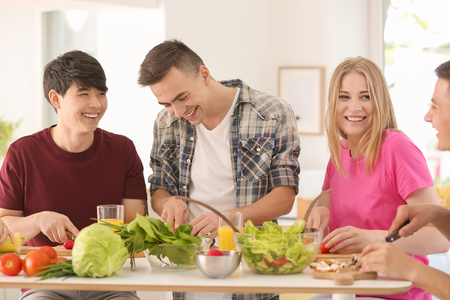Friends cooking together in kitchenの写真素材