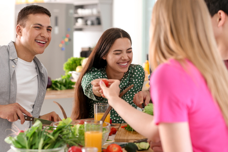 Friends cooking together in kitchenの写真素材