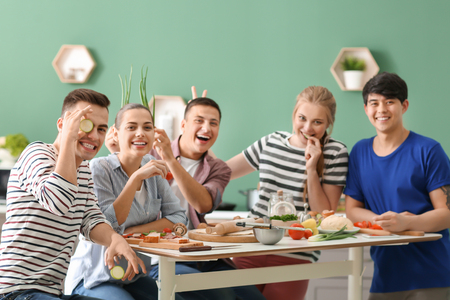 Young friends having fun while cooking in kitchenの写真素材