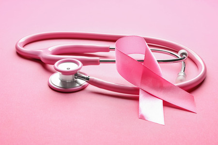 Pink ribbon and stethoscope on color background. Breast cancer awareness conceptの写真素材