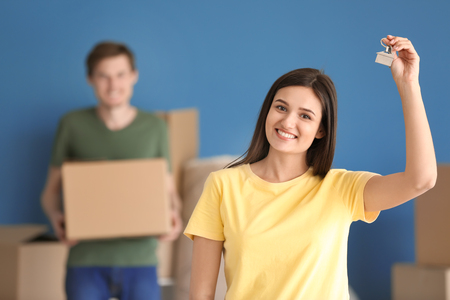 Young happy woman with key at new home