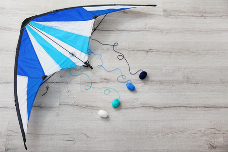 Colorful kite with knitting yarn on wooden backgroundの写真素材