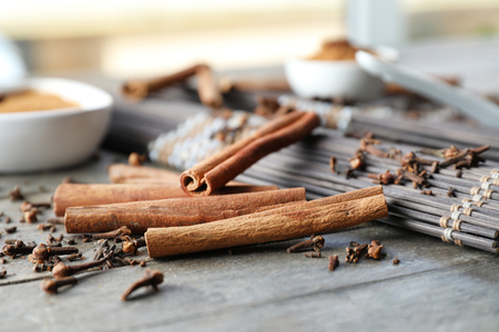 Aromatic cinnamon sticks and spices on wooden table, closeupの写真素材