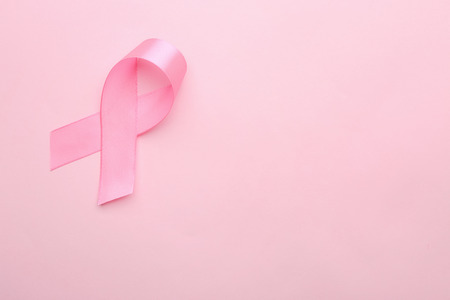 Pink ribbon on color background. Breast cancer conceptの写真素材