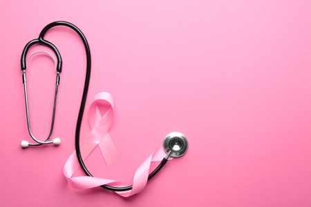 Pink ribbon and stethoscope on color background. Breast cancer awareness conceptの写真素材