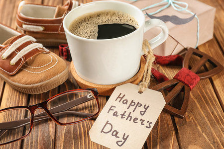 Composition with cup of coffee, gift box and male accessories on wooden background. Happy Father's Day celebrationの写真素材