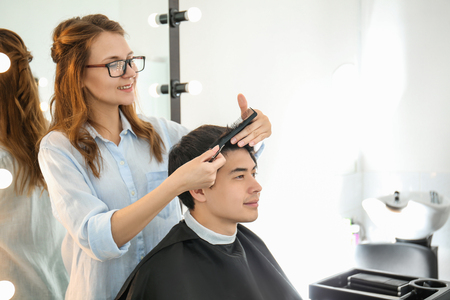 Professional hairdresser working with client in beauty salonの写真素材