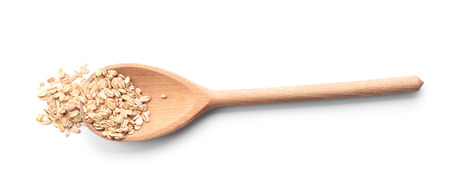 Spoon with raw oatmeal on white backgroundの写真素材