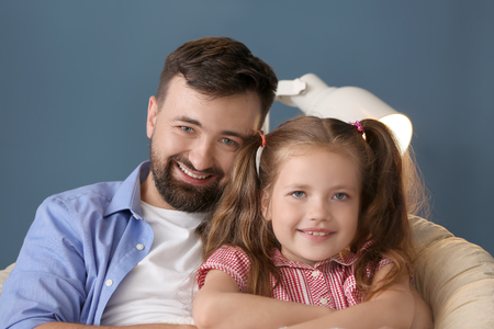 Portrait of smiling father and daughter at homeの写真素材