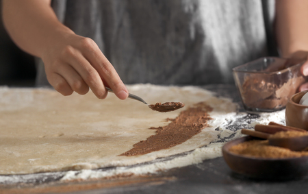 Woman making cinnamon rolls in kitchenの写真素材