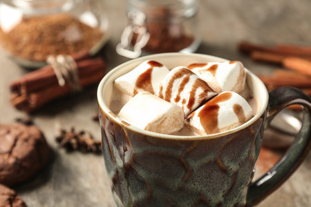 Cup of delicious hot cocoa with marshmallows on wooden tableの写真素材