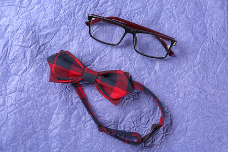Glasses and bow-tie on color textured background. Happy Father's Day celebrationの写真素材