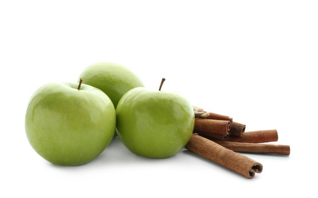 Fresh apples and cinnamon sticks on white backgroundの写真素材