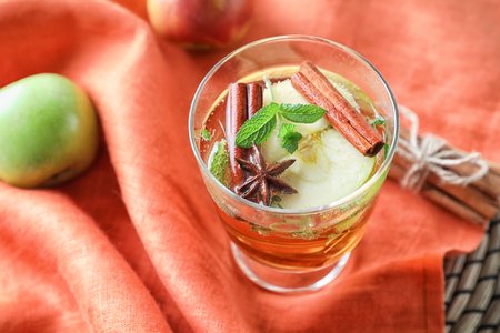 Glass of tasty apple drink with cinnamon on napkinの写真素材