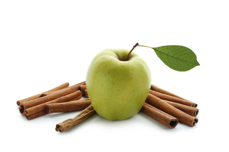 Fresh apple and cinnamon sticks on white backgroundの写真素材