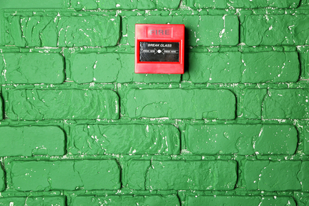 Modern fire call point on brick wall indoorsの写真素材