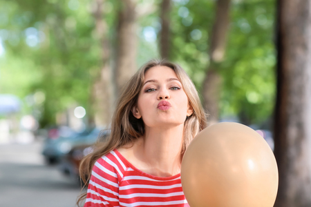 Beautiful young woman with balloons outdoorsの写真素材