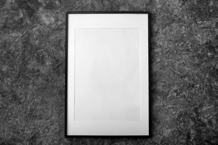 Blank photo frame hanging on dark wallの写真素材