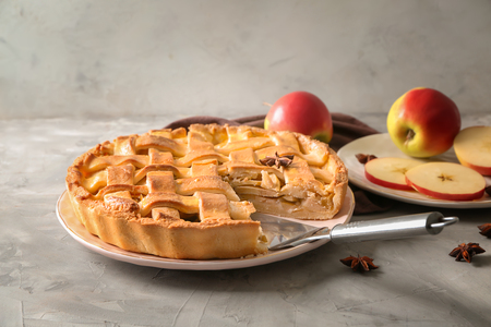 Plate with delicious apple pie on table against light backgroundの写真素材