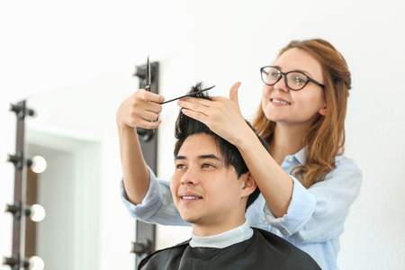 Professional hairdresser working with client in beauty salonの写真素材