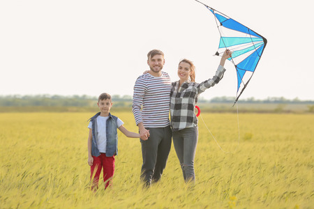 Happy family flying kite in the fieldの写真素材