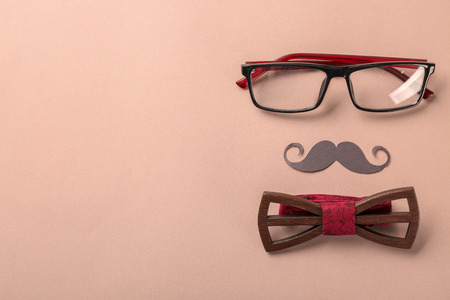 Black mustache, glasses and bow-tie on color background. Happy Father's Day celebrationの写真素材
