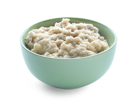 Tasty oatmeal in bowl on white backgroundの写真素材