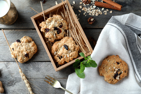 Wooden tray with delicious oatmeal cookies on tableの写真素材