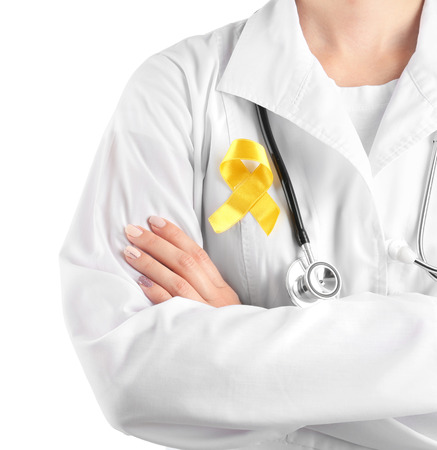 Doctor with yellow ribbon on robe against white background. Cancer awareness conceptの写真素材